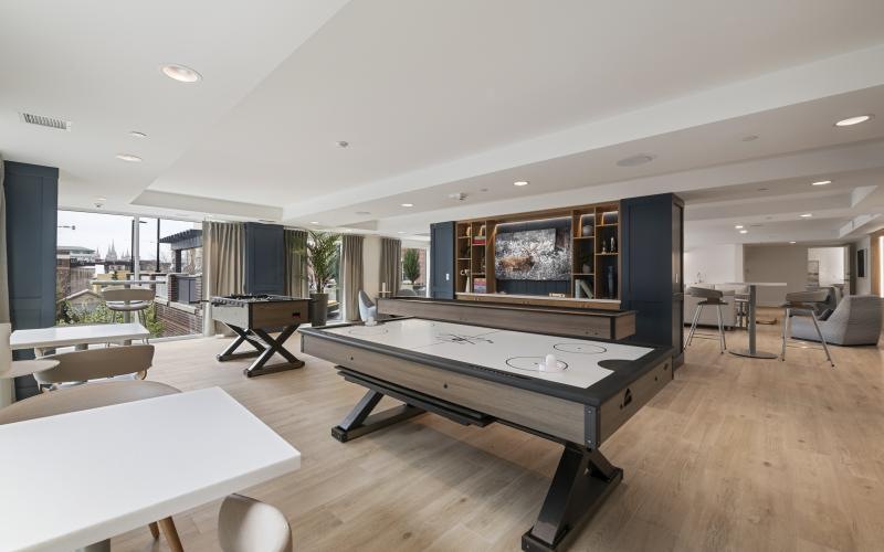 a room with tables, chairs and an air hockey table