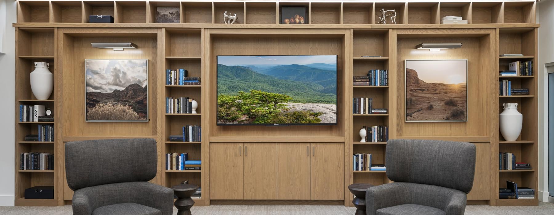 a room with a table chairs and a tv centered in a bookshelf